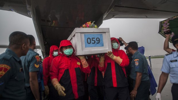 Indonesian rescue personnel unload a coffin bearing a body recovered from the underwater wreckage of ill-fated AirAsia flight QZ8501 from a military plane on arrival at Surabaya.