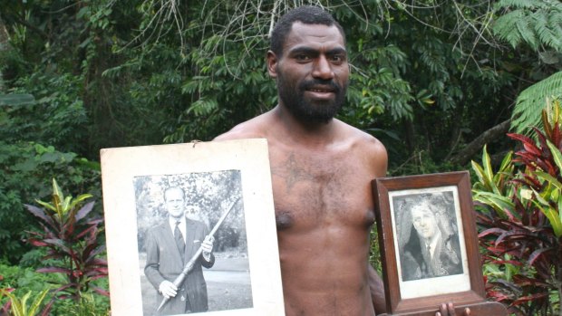 A resident of the Pacific island of Tanna with photos of Prince Philip.