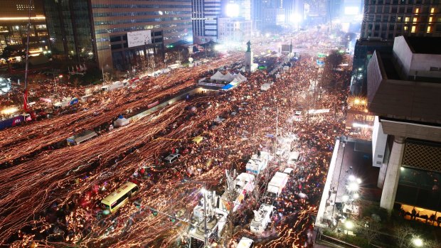Thousands of protesters march toward the presidential house in a candlelight procession against South Korean President Park Geun-hye in Seoul on Saturday.