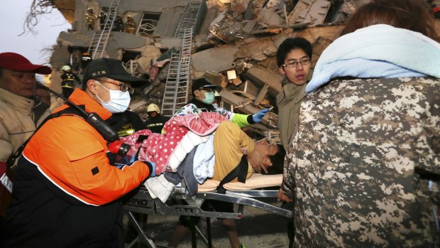 Rescue workers carry a man from the site of a toppled building in Tainan, Taiwan.