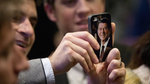 A man uses his mobile phone, with a photo of president Ronald Reagan on it, to take pictures of Ted Cruz at an event in Washington on December 10.