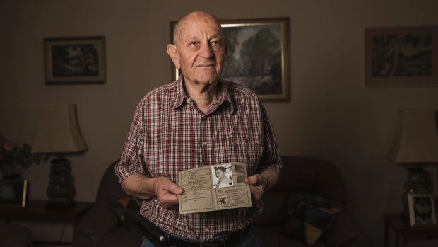 Holocaust survivor Peter Witting holds his Jewish identity card. 