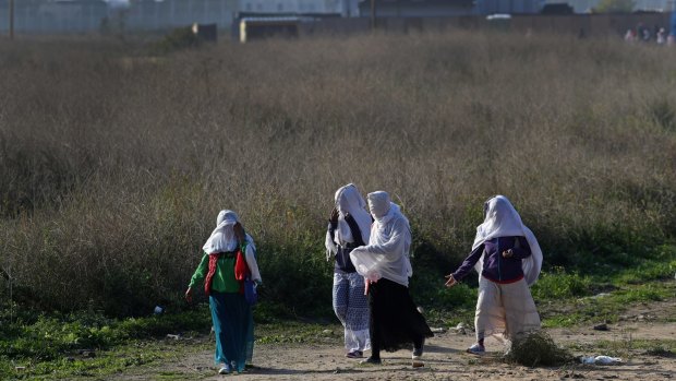 A group of migrant women walk through the Jungle migrant camp in Calais, France. 