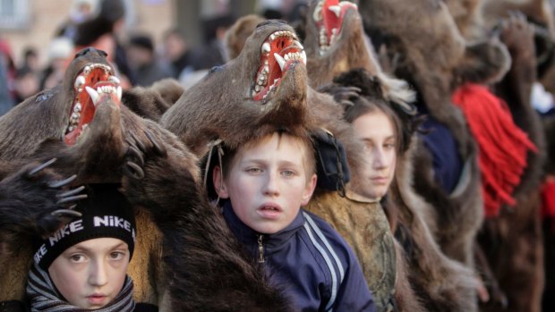 Children wear bear furs during New Year ritual dances in Romania.