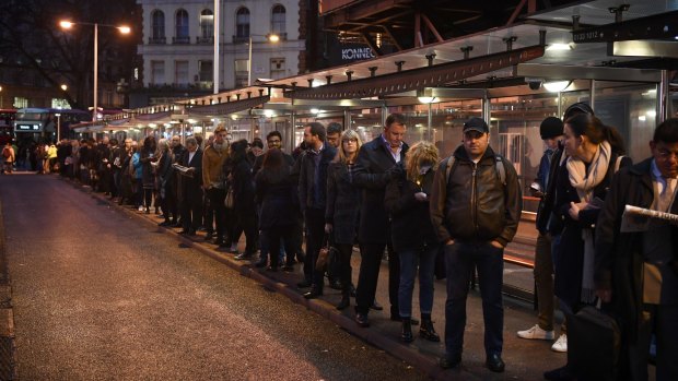 Commuters queue for buses at Victoria Station. 