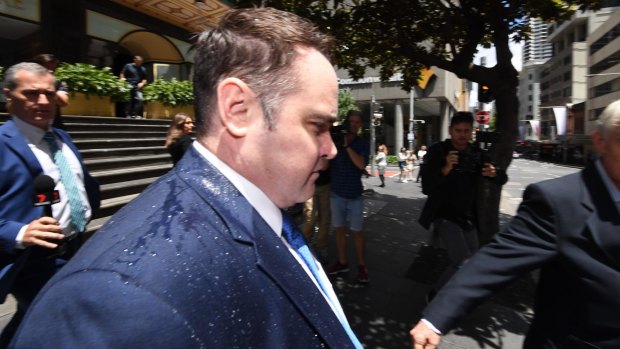 Drenched former Nine Journalist Ben McCormack leaves the Downing Centre court complex on Wednesday.