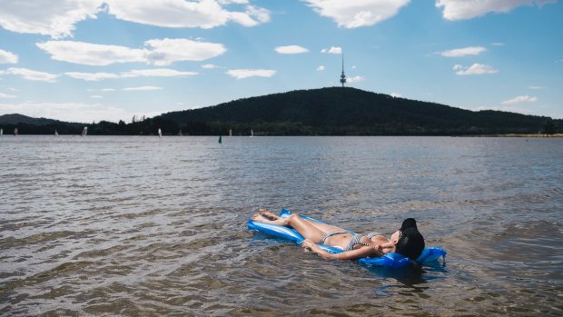 Canberrans are returning to the lake. Kelly Dixon of Lyneham sunbaths on the water earlier this month.