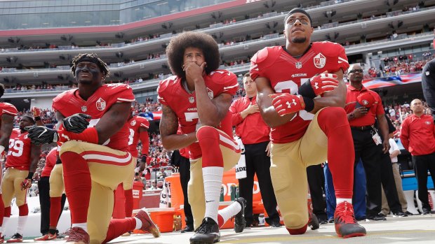 Protest: Eli Harold, Colin Kaepernick and safety Reid kneel during the national anthem.