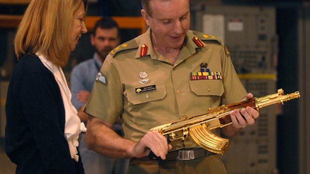 Major-General John Cantwell hands the gold-plated assault rifle to then War Memorial executive Nola Anderson in 2007.