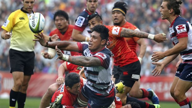 Lopes Timpani of the Rebels passes as he is tackled during the round four match against Japan's Sunwolves in Tokyo.