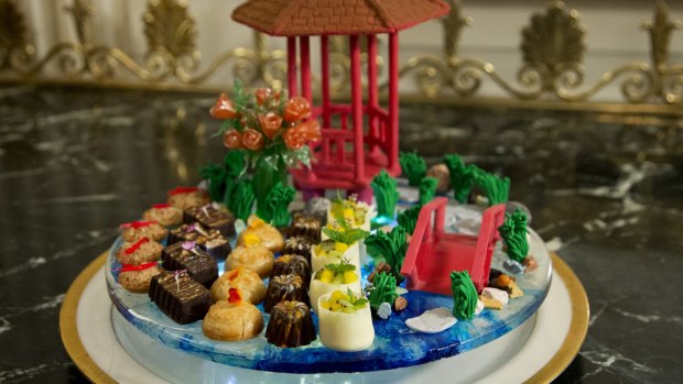 The dessert called "a stroll through the garden" composed of a handmade chocolate pavilion and bridge, pulled sugar roses and white lotus flowers, which symbolise good fortune for the White House banquet.