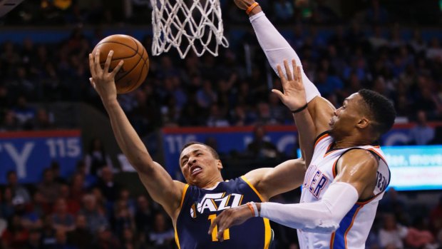 Utah Jazz guard Dante Exum (left) shoots in front of Oklahoma City Thunder guard Russell Westbrook.