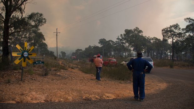 Vanessa and Kevin Lesley watch on as the fire burns in the distance, shortly before their own property was destroyed.