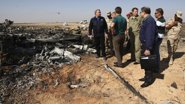 Russian Emergency Situations Minister Vladimir Puchkov, left, talks with Russian Transport Minister Maxim Sokolov, fifth right, as they inspect the wreckage of a passenger jet bound for St Petersburg that crashed in Egypt.