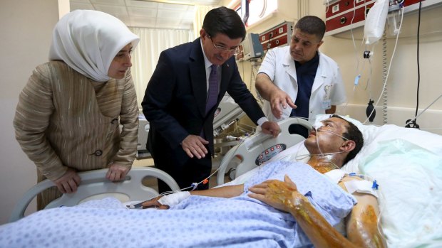 Turkish Prime Minister Ahmet Davutoglu (second from left) visits a survivor of the attack.