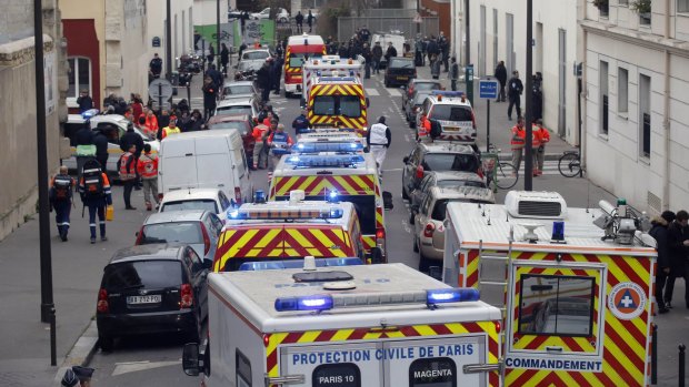 Ambulances lined the street outside the French satirical newspaper Charlie Hebdo's office after masked gunmen stormed the newspaper, killing 12 people. 