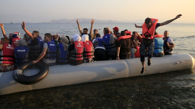 Syrian refugees rush to shore on Kos.