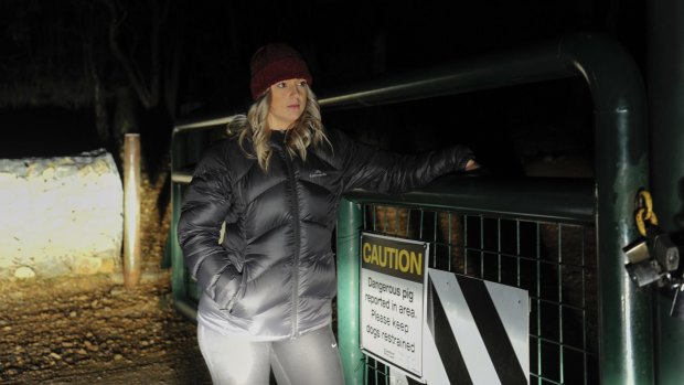 Michaela Vodvarka at Mount Jerrabomberra on Monday night near a sign warning of a dangerous pig.