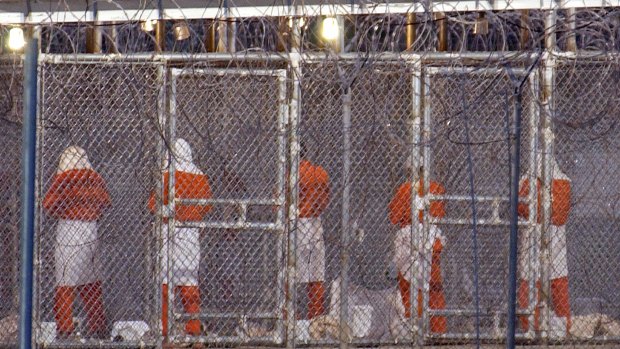 Detainees at Camp X-Ray face Mecca during evening prayers.