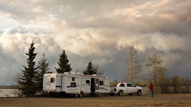 Evacuees camp by a lake as smoke fills the sky near Fort McMurray, Alberta, on Wednesday.