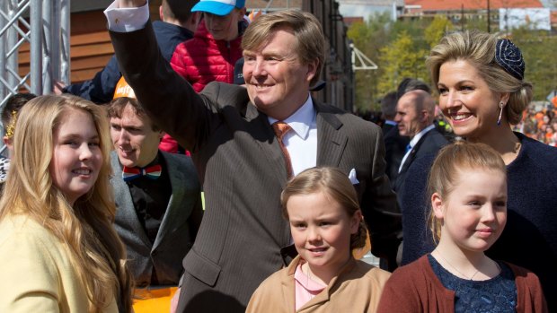 Dutch King Willem-Alexander greets well-wishers as he poses with his wife Queen Maxima, and their children Princesses Amalia, left, Ariane, centre, and Alexia.
