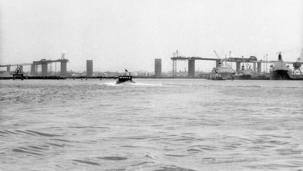A photograph taken from the water shows the area missing from the bridge after the span crash.
