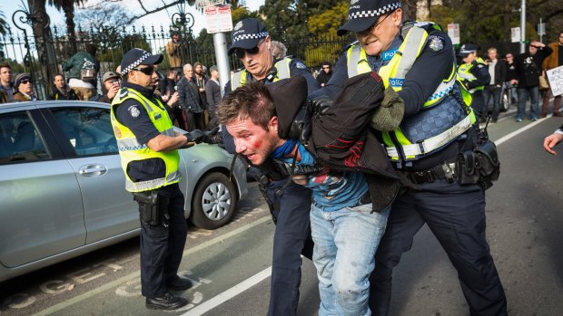 Police lead a member of the United Patriots Front  away during the July 18 rally. 