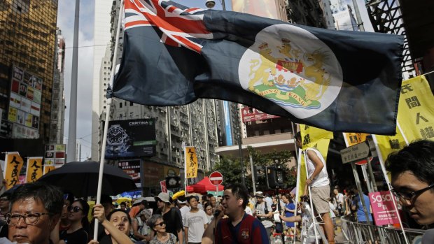 A protester raises a Hong Kong colonial flag during a pro-democracy protest on Wednesday on the 18th anniversary of the territory's handover from Britain to China.
