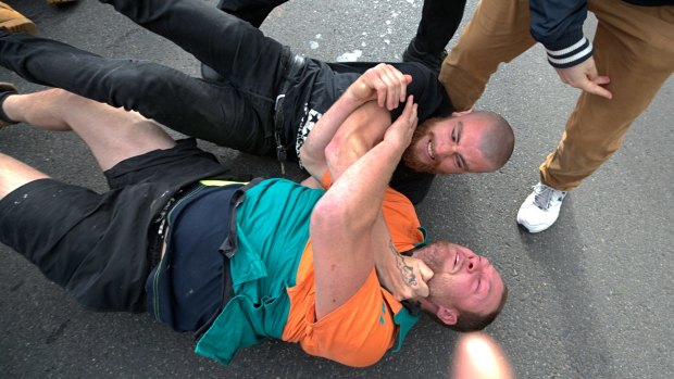 Rival protesters wrestle.