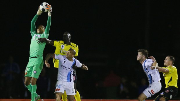 Melbourne City goalkeeper Tando Velaphi leaps high to effect a save.