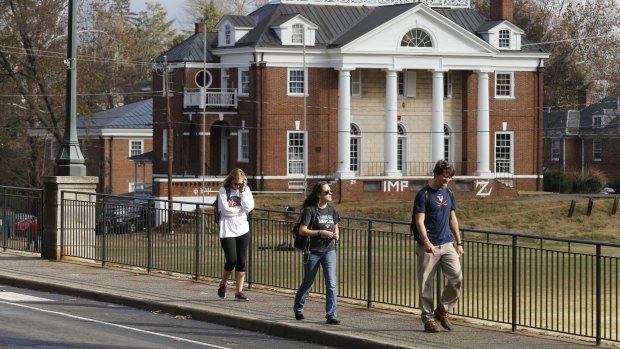 University of Virginia students walk to campus past the Phi Kappa Psi fraternity house at the University of Virginia in Charlottesville.