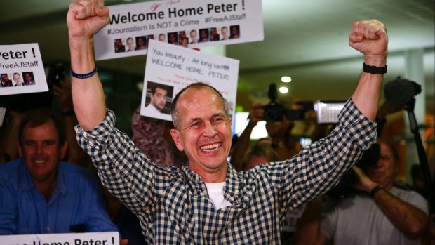 Al-Jazeera journalist Peter Greste punches the air upon his arrival at Brisbane's international airport.