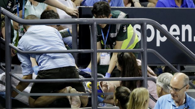 Medical staff attend to the injured fan on a stairwell