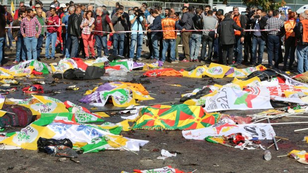 Bodies of victims are covered with flags and banners of the opposition HDP and Kurdish colours at  the site of the Ankara bombing.