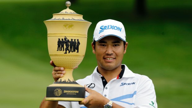 Japan's Hideki Matsuyama holds up The Gary Player Cup trophy after his runaway win at Firestone.