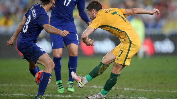 Winning strike: Australia's Mathew Leckie shoots past Greece's Marios Oikonomou to score a late goal at ANZ Stadium.