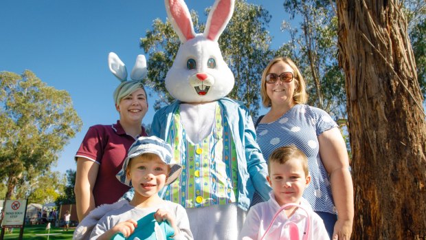 L-R: Easter bunny wrangler Taya, four-year-old Lucas Ramirez from Calwell, the Easter bunny, Kerrie-Anne Ramirez, and four-year-old Kaden Graeber from Monash.