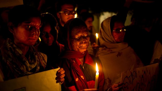 Acid attack survivors participate in a candlelit vigil protesting violence against women.