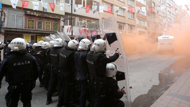 Turkish riot police officers hold their positions during clashes with demonstrators in Istanbul on Friday.