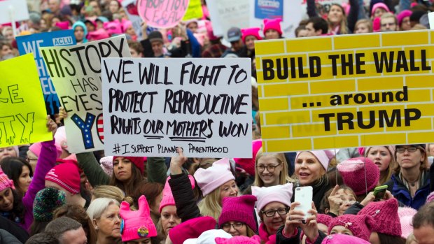 Women holding placards begin the march.