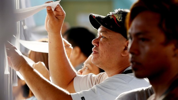 Filipino voters check the voters' lists in the front-running presidential candidate Mayor Rodrigo Duterte's hometown of Davao city on Monday. 