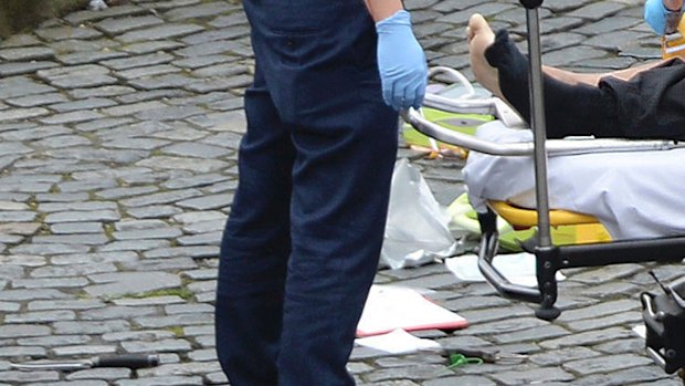 A man is treated by emergency services, as a knife lays on the floor, outside the Houses of Parliament London on Wednesday.