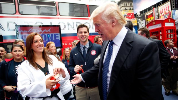Donald Trump with taekwondo athlete Diana Lopez and fencer Tim Morehouse (centre) in New York on Monday. 