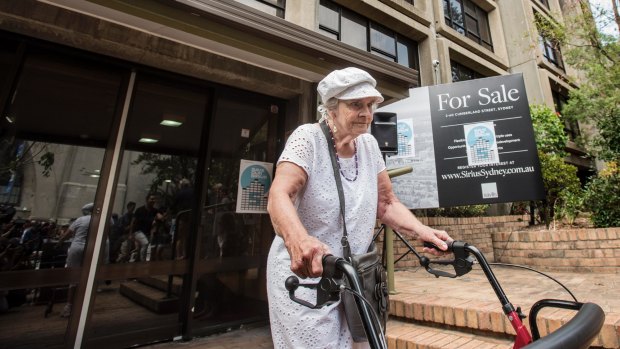 Myra Demetriou, the last resident of the iconic Sirius building in The Rocks, passes a "For Sale" sign for the site.