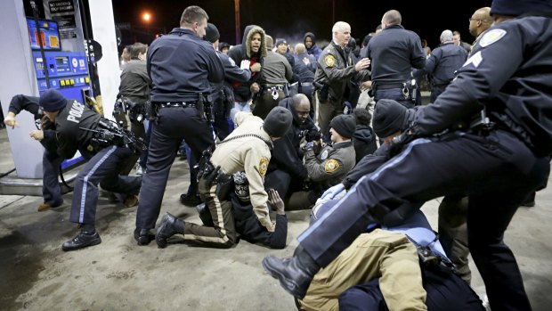 Police seize members of the crowd at the gas station where Antonio Martin was killed after allegedly drawing a gun.