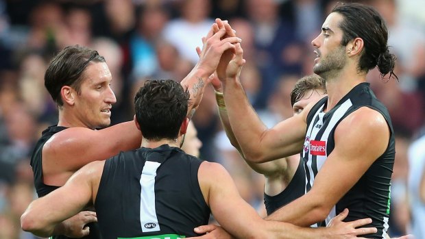 Brodie Grundy of the Magpies is congratulated by teammates after kicking a goal.