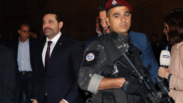 Lebanese Prime Minister Saad Hariri, left, walks to pray over his father's grave.