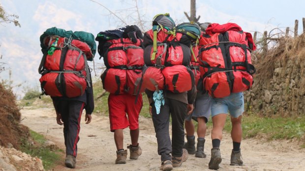 Porters carrying our red duffel bags.