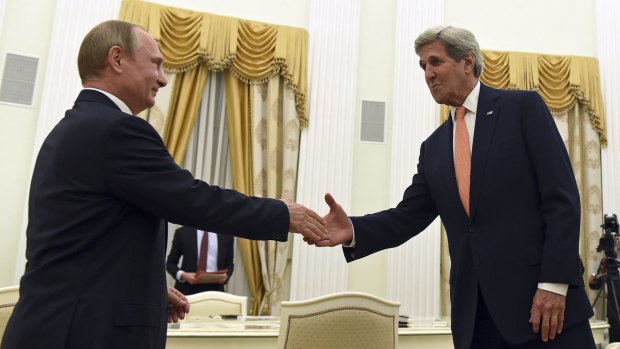 Russian President Vladimir Putin, left, and US Secretary of State John Kerry reach out in the Kremlin on Thursday evening.