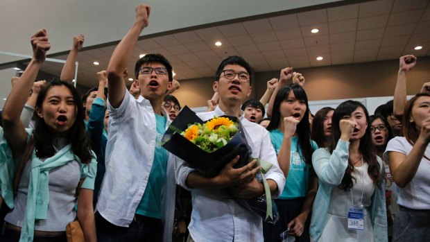 Nathan Law, centre, of the political party Demosisto, celebrates with teen protest leader Joshua Wong, second from left, and his supporters after winning a seat at the legislative council elections.